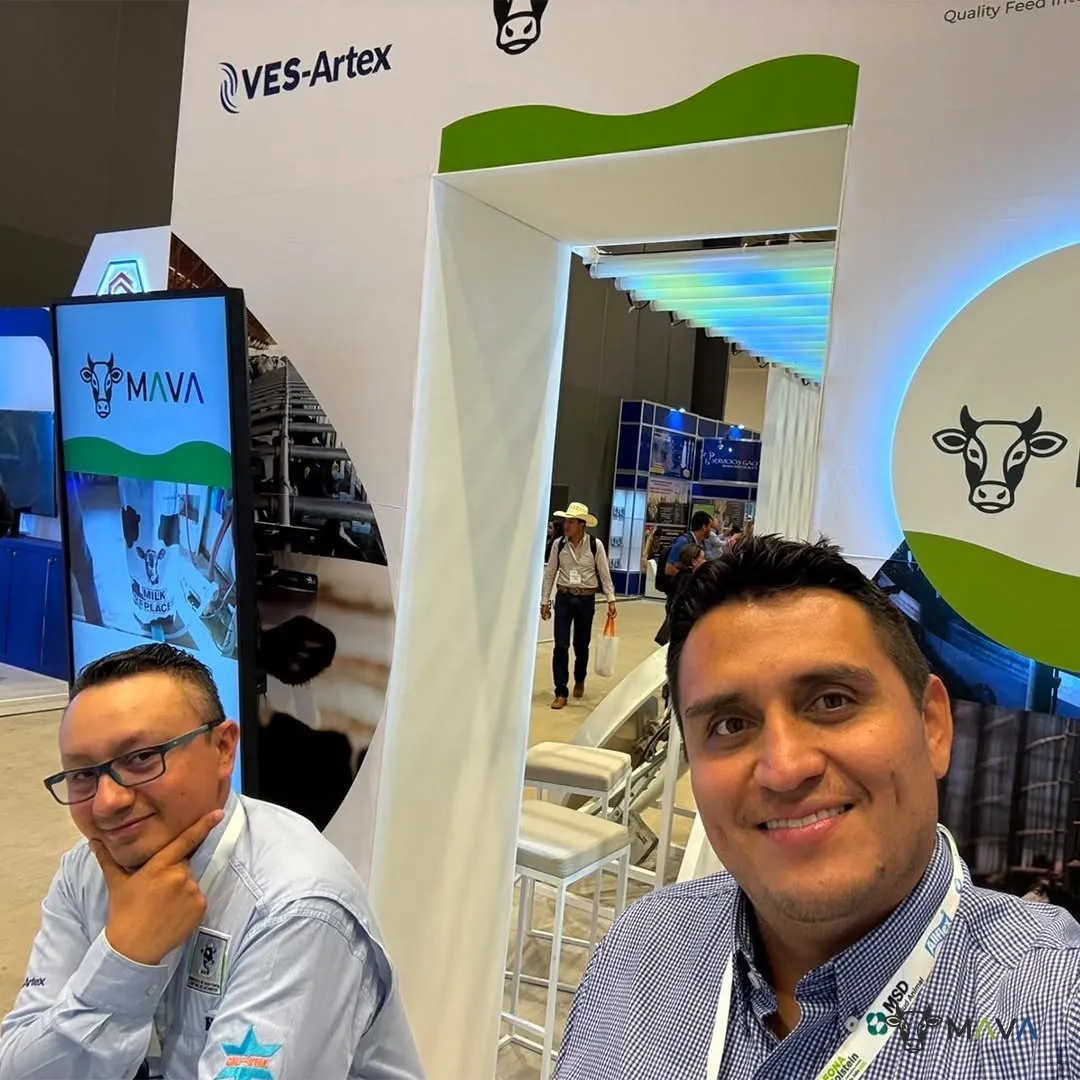 Dos personas en primer plano dentro del stand, con una pantalla de Mava y el logo de VES-Artex al fondo.